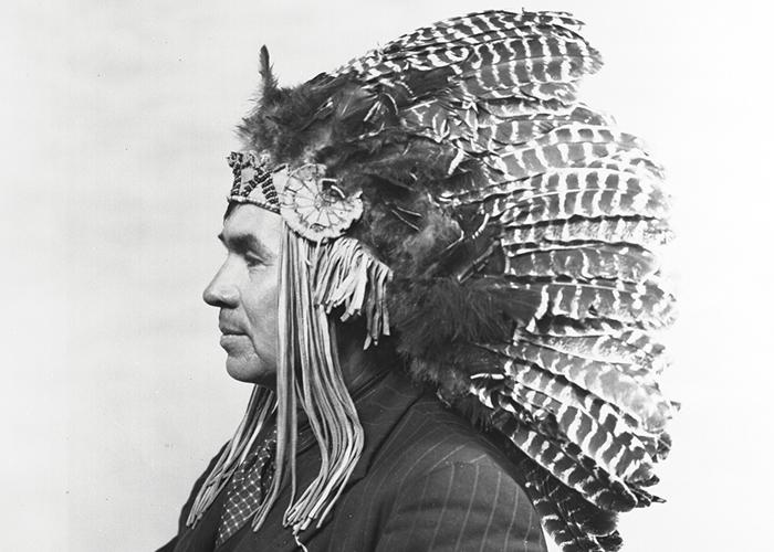 Binaaswi wearing a pinstripe suit and headdress.