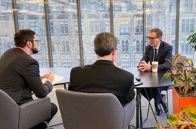 Governor Macklem seated at a table with two other individuals engaging in conversation.