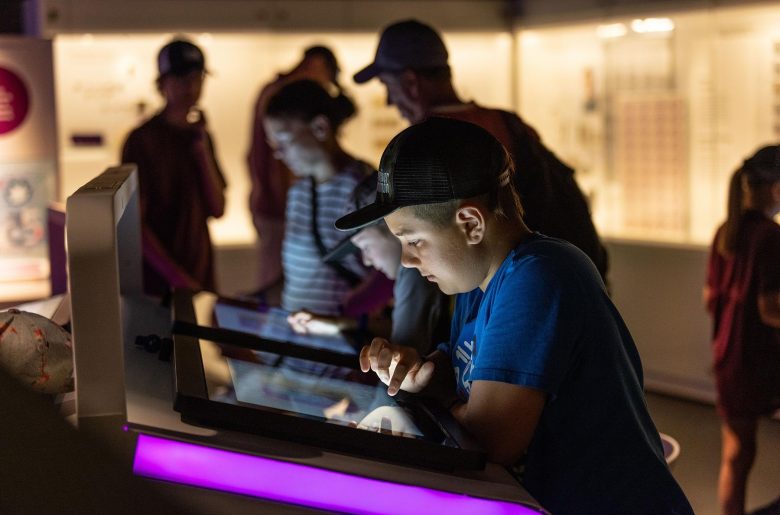 Child interacting with a digital pad at the Bank of Canada Museum.