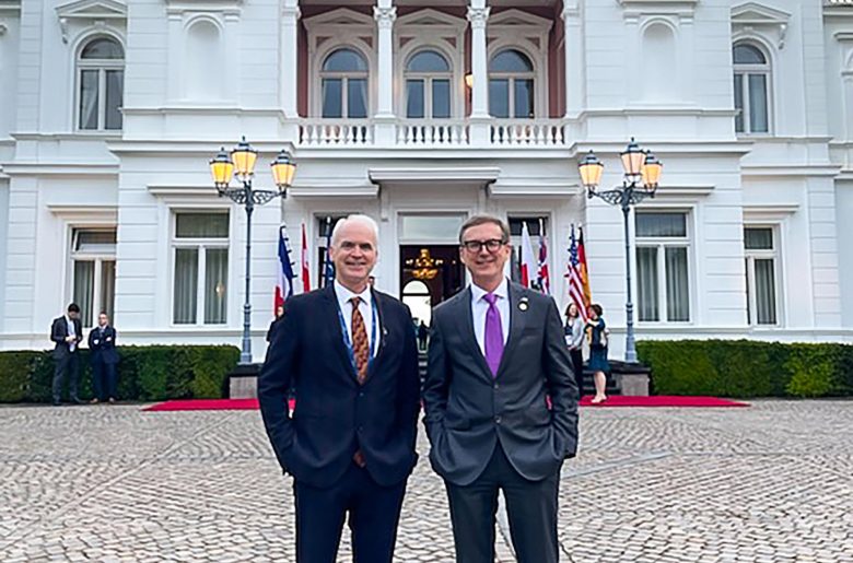 Deputy Governor Beaudry and Governor Macklem standing side by side in front of a building smiling towards the camera.